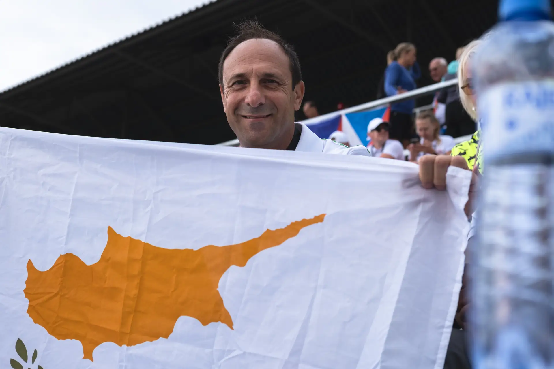 dragon boat cyprus national team paddler holding cyprus flag